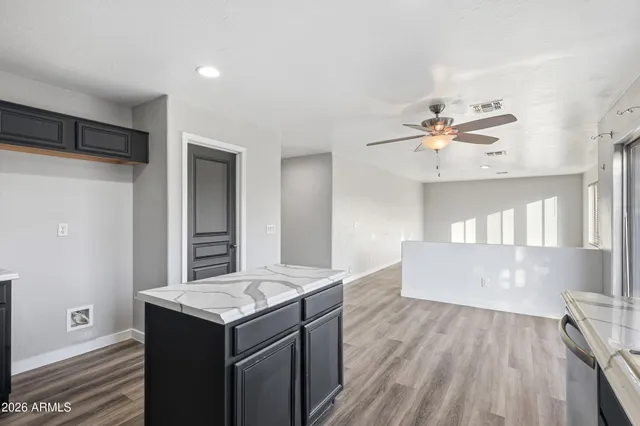 a kitchen with a wooden floor and electronic appliances
