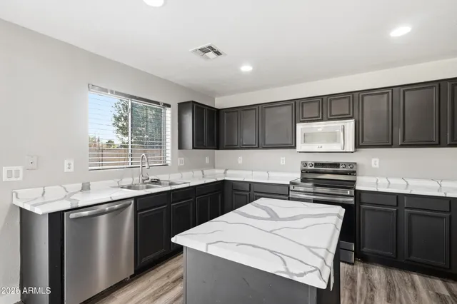 a kitchen that has a sink and a stove in it