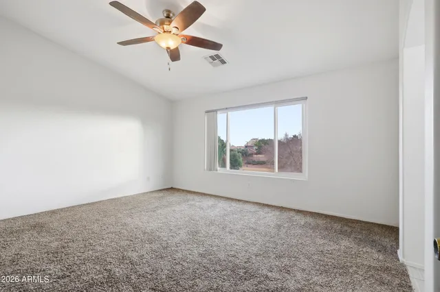 an empty room with windows and fan
