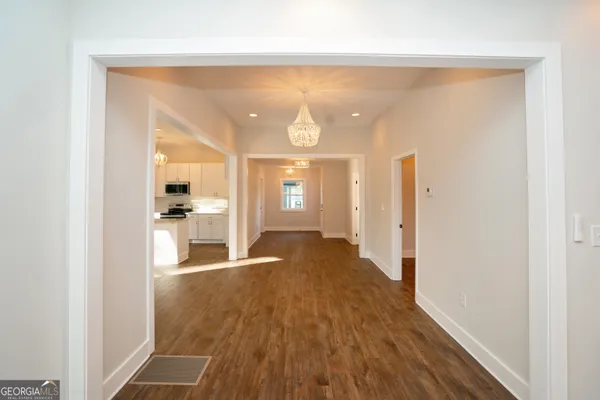 a large kitchen with kitchen island granite countertop a window and a white cabinets