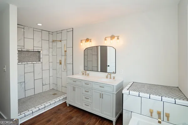 a view of a hallway to room with wooden floor