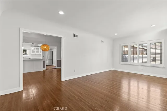 a view of a kitchen with wooden floor and a window