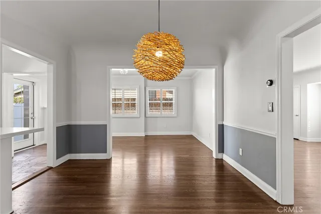 a hallway with wooden floor windows and chandelier