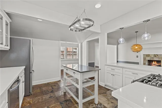 a view of a kitchen with a sink and dishwasher with white cabinets