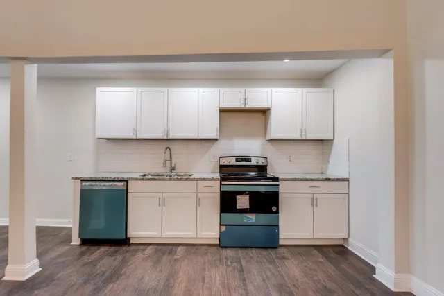 a bathroom with a granite countertop toilet a sink and a bathtub