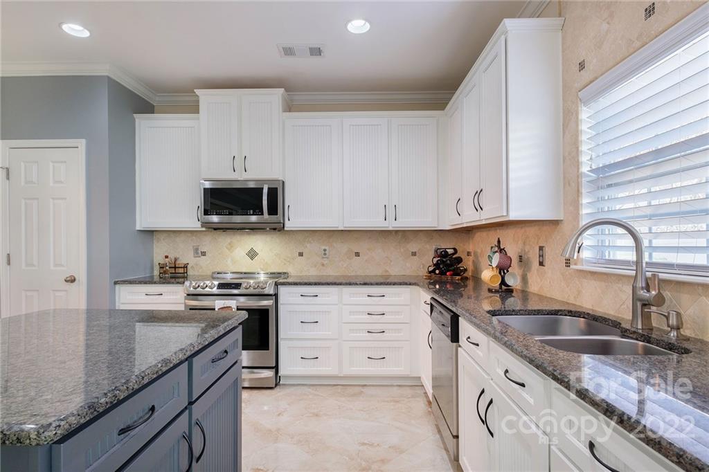 14410 Winged Teal Road Charlotte, NC 28278 - Photo 12 of 38 a kitchen with stainless steel appliances granite countertop a sink stove top oven and cabinets