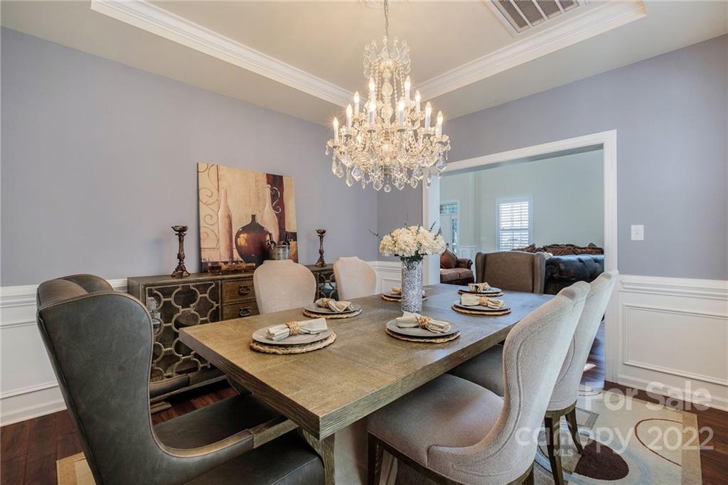 14410 Winged Teal Road Charlotte, NC 28278 - Photo 8 of 38 a view of a dining room with furniture a chandelier and wooden floor