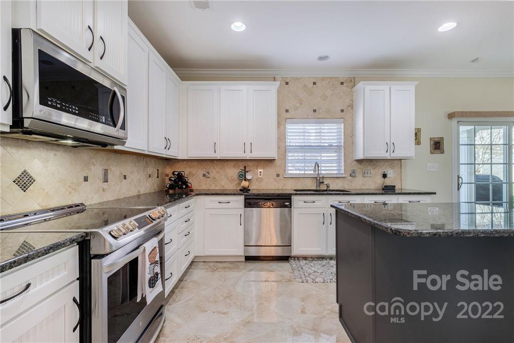 14410 Winged Teal Road Charlotte, NC 28278 - Photo 10 of 38 a kitchen with stainless steel appliances granite countertop a stove a sink and a microwave