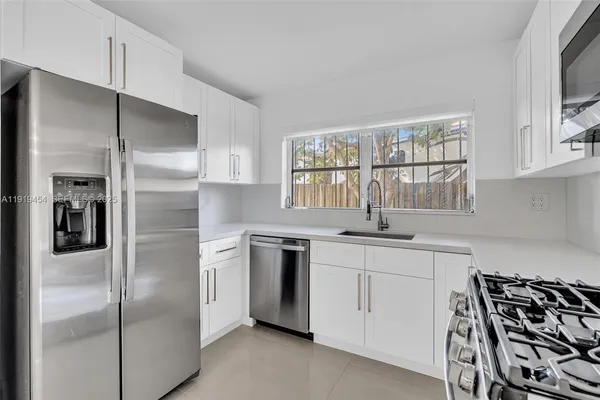 a kitchen with white cabinets and stainless steel appliances