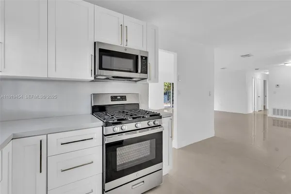 a kitchen with stainless steel appliances granite countertop a refrigerator and a stove
