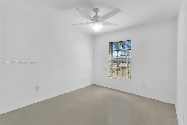 a bedroom with a bed a couch and a flat tv screen on the dresser