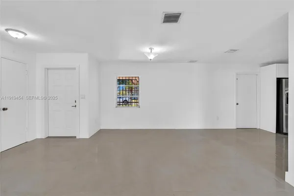 a view of a livingroom with an empty space and a window