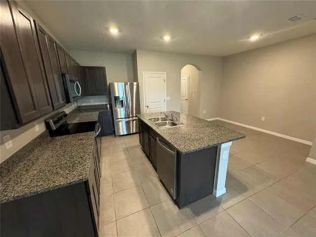a kitchen with stainless steel appliances granite countertop a sink and a stove