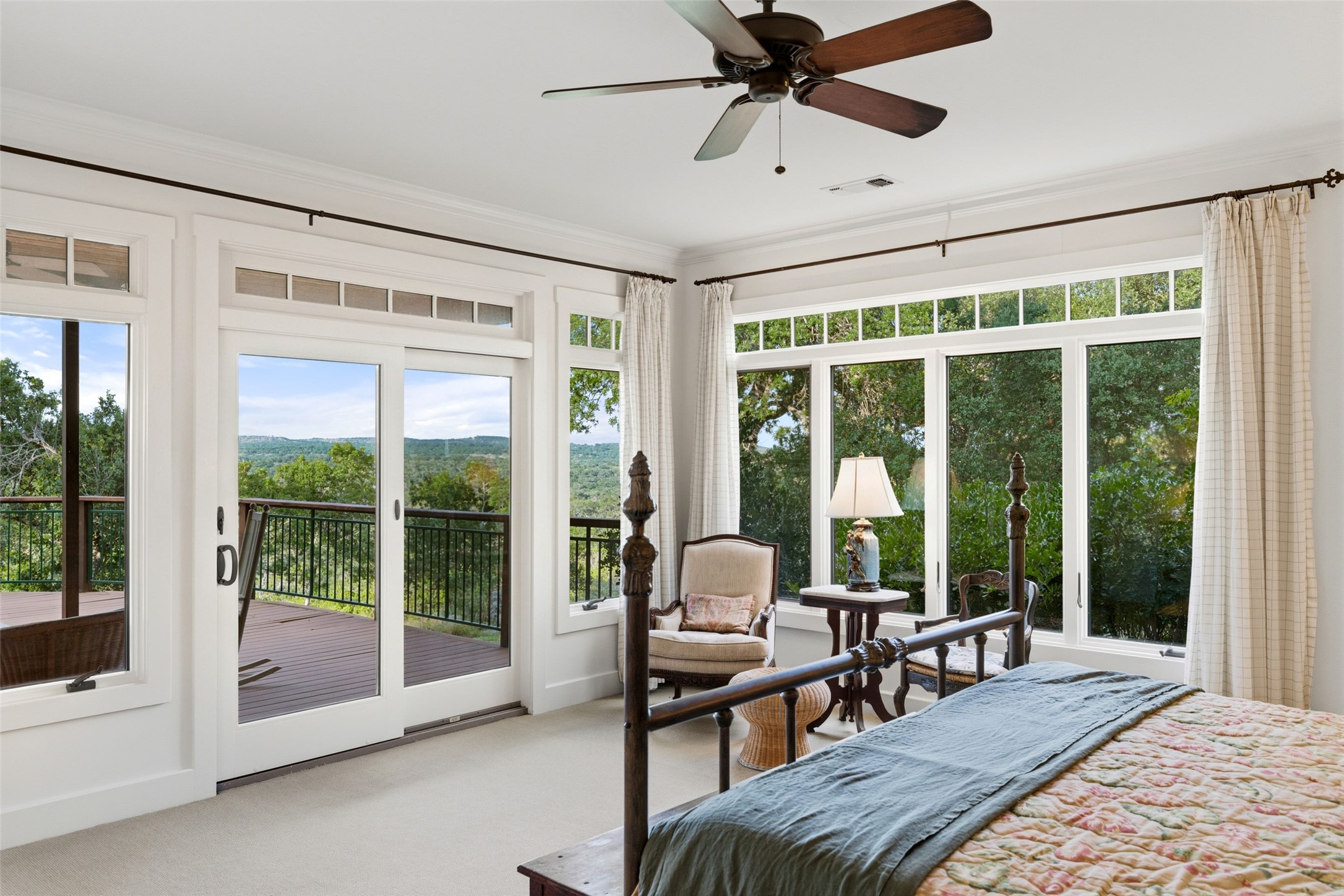 505 Red Corral Ranch Road Wimberley, TX 78676 - Photo 33 of 40 Unwind in this serene bedroom, boasting panoramic green views and direct deck access.