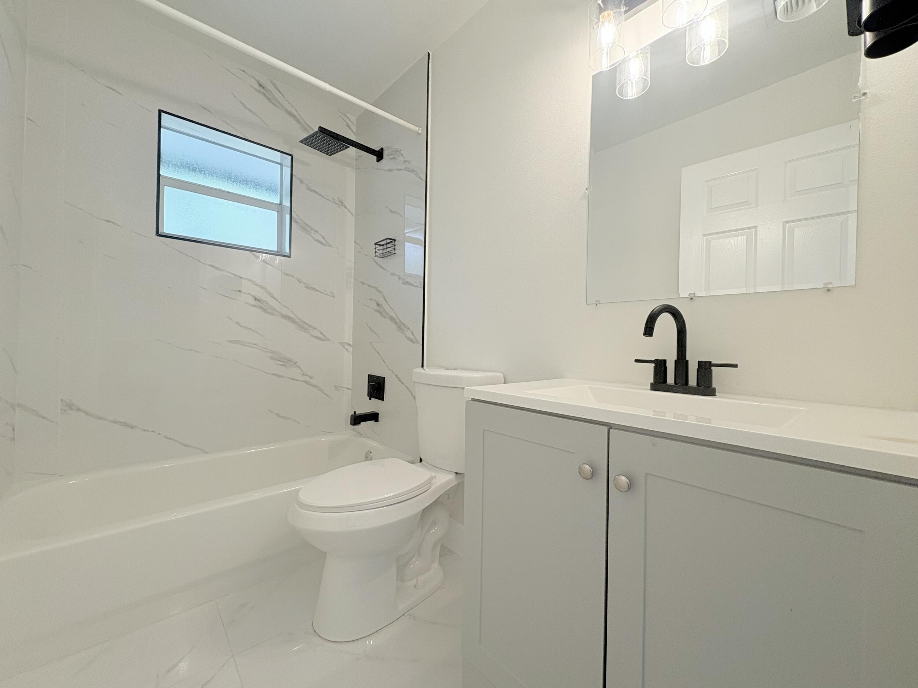14523 Flamingo Road Loxahatchee Groves, FL 33470 - Photo 34 of 50 a bathroom with a sink a toilet and a bathtub