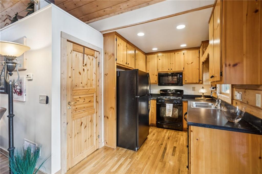 458 Tea Berry Lane Big Canoe, GA 30143 - Photo 8 of 37 a kitchen with stainless steel appliances granite countertop a refrigerator a stove and a sink with wooden floor