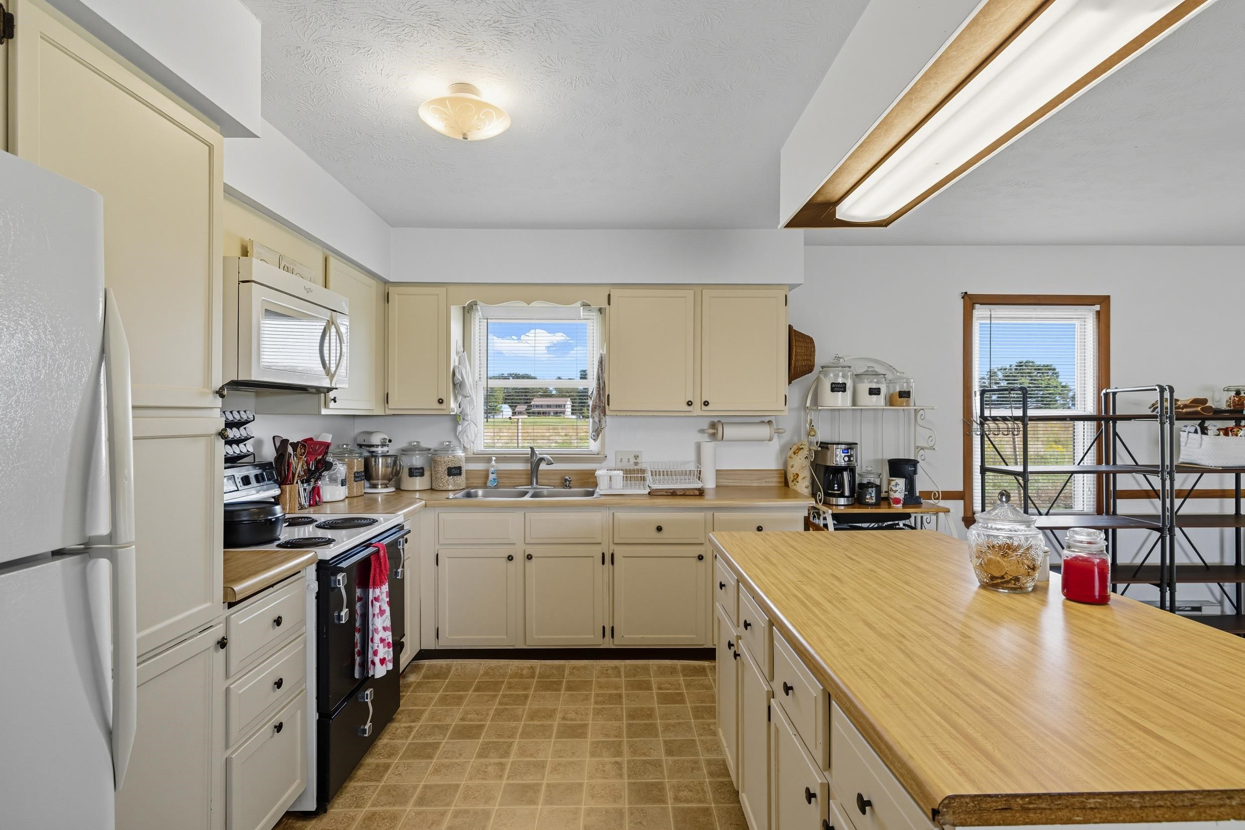 9108 Nazarene Church Road Bridgewater, VA 22812 - Photo 4 of 72 a kitchen with a sink dishwasher stove and white cabinets next to a window