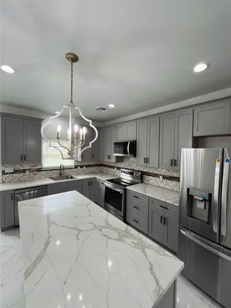 a large kitchen with stainless steel appliances granite countertop a sink refrigerator stove and microwave