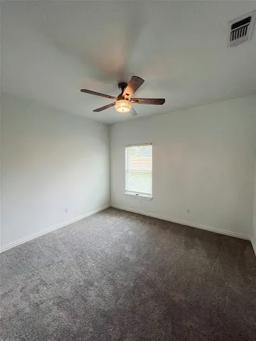 a view of an empty room with a ceiling fan