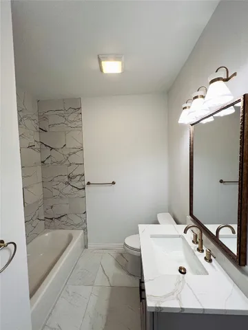 a bathroom with a bathtub sink and mirror