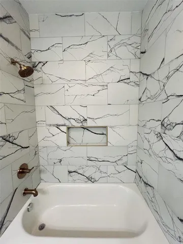 a bathroom with a bathtub and shower