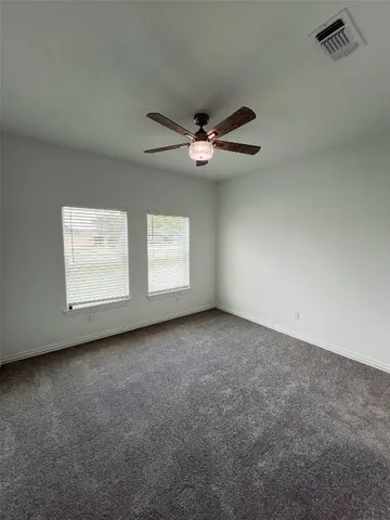 an empty room with windows and fan