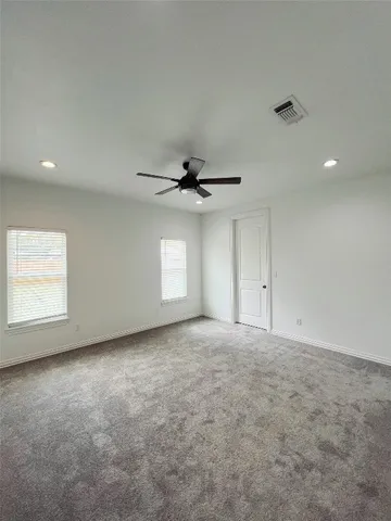 an empty room with windows and fan window