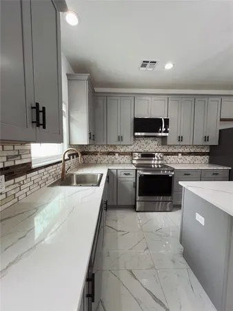 a large kitchen with a stove top oven a sink dishwasher and a refrigerator with wooden cabinets