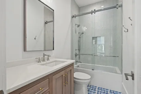 a kitchen with stainless steel appliances granite countertop a stove top oven a sink a dining table and chairs with wooden floor