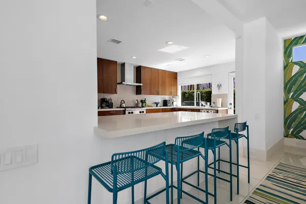 a kitchen with stainless steel appliances a table and chairs in it