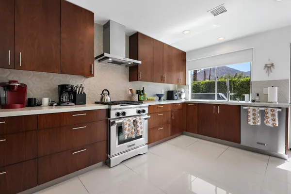 a kitchen with stainless steel appliances granite countertop a stove a sink and a refrigerator