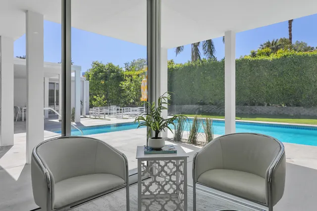 a living room filled with furniture and a floor to ceiling window