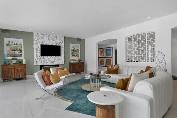 a living room with furniture a fireplace and a flat screen tv