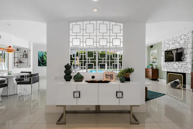 a living room with furniture a fireplace and a floor to ceiling window