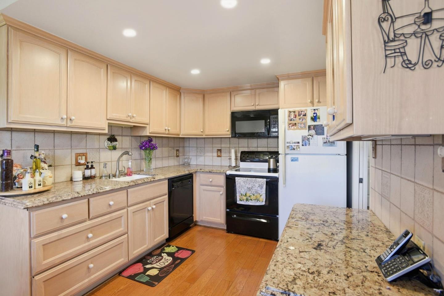 815 Rigel Lane Foster City, CA 94404 - Photo 12 of 48 a kitchen with kitchen island granite countertop a sink cabinets and stainless steel appliances