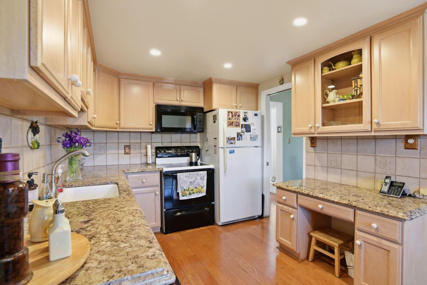 815 Rigel Lane Foster City, CA 94404 - Photo 13 of 48 a kitchen with kitchen island granite countertop a stove top oven a sink a counter space and cabinets