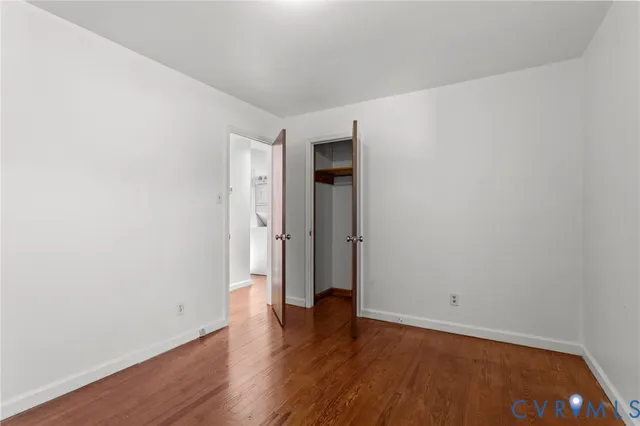 an empty room with wooden floor and closet