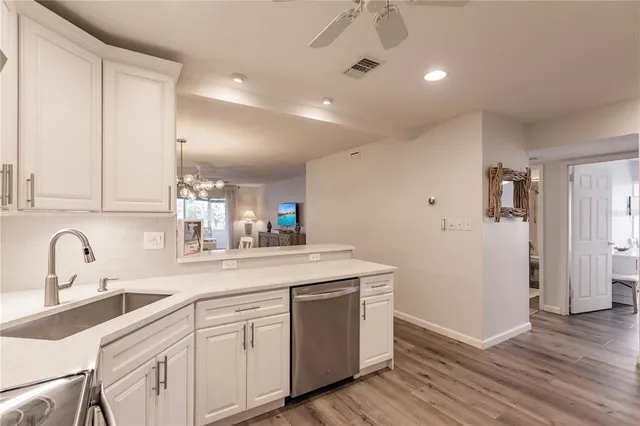 a kitchen with a sink cabinets and wooden floor