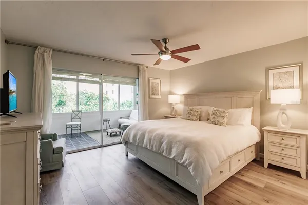 a bedroom with a large bed a large window and flat screen tv