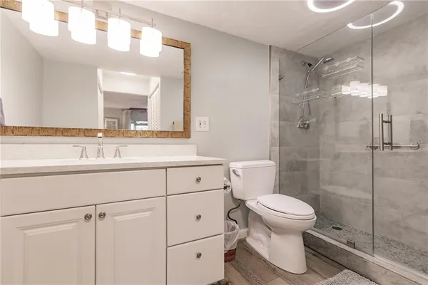 a bathroom with a sink a toilet and shower