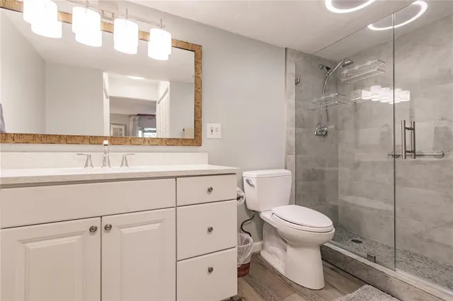 a bathroom with a sink a toilet and shower