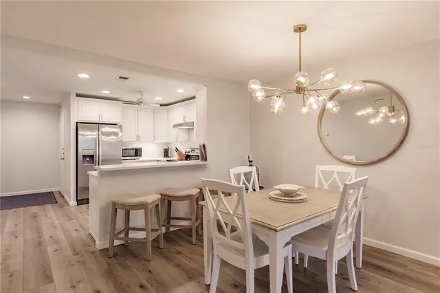 a kitchen with kitchen island a dining table chairs and a chandelier