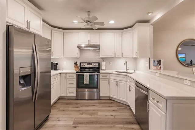 a kitchen with stainless steel appliances cabinets a sink and a center island