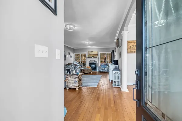a dining room with wooden floor a chandelier a wooden table and chairs