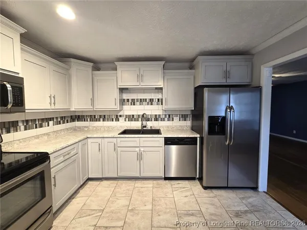 a kitchen with a sink stove and refrigerator