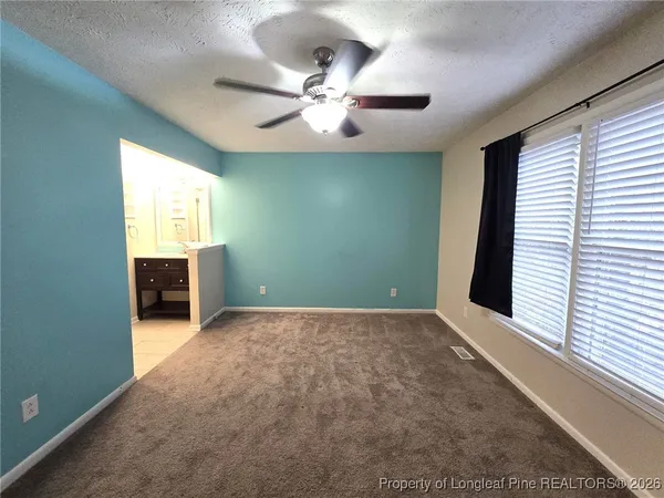 an empty room with windows and cabinet