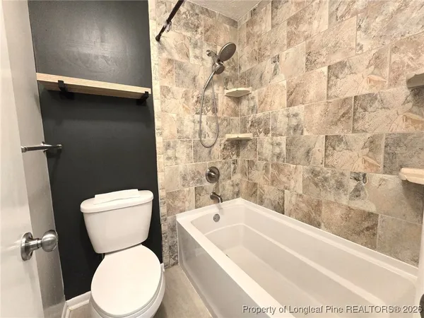 a white toilet sitting next to a bathtub