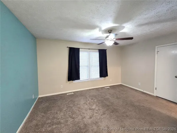 a view of an empty room with a ceiling fan