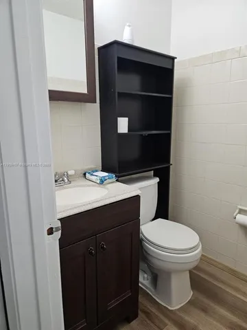 a bathroom with a toilet a sink and mirror