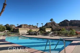 a view of a swimming pool with a patio and a yard